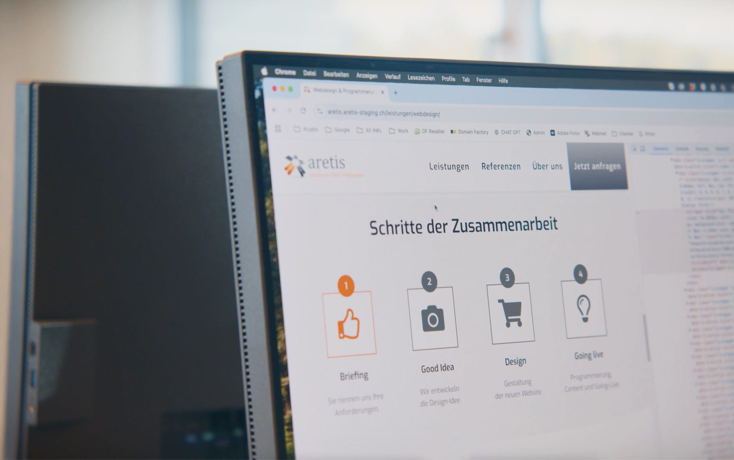 Computer monitor zeigt deutsche Website mit Icons zu Briefing, Idee, Design und Livegang.